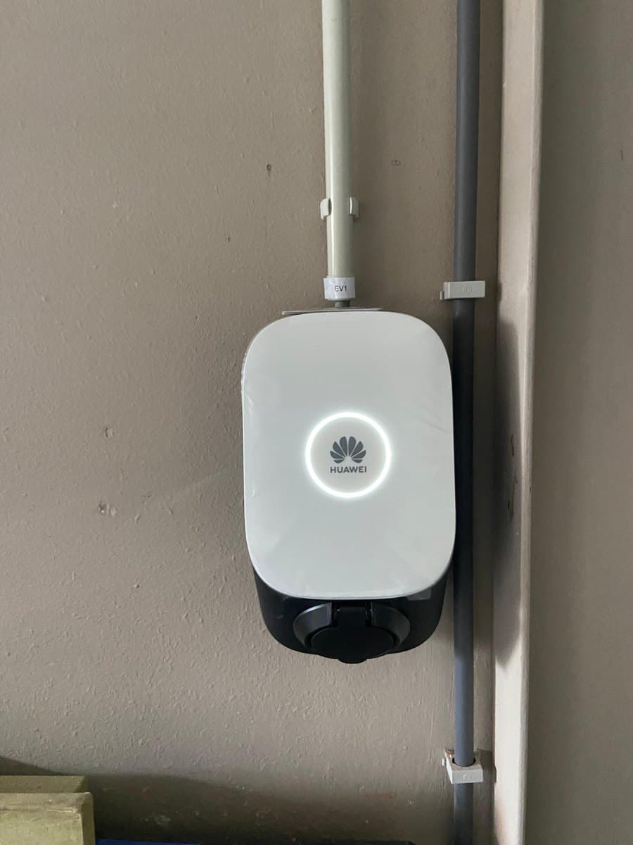 Laadpaal aan een garagemuur, met de voeding in een buis weggewerkt