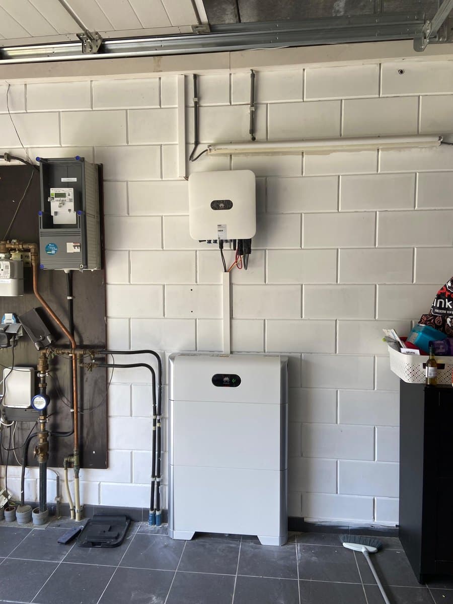 Omvormer en thuisbatterij in een garage, naast de meterkast