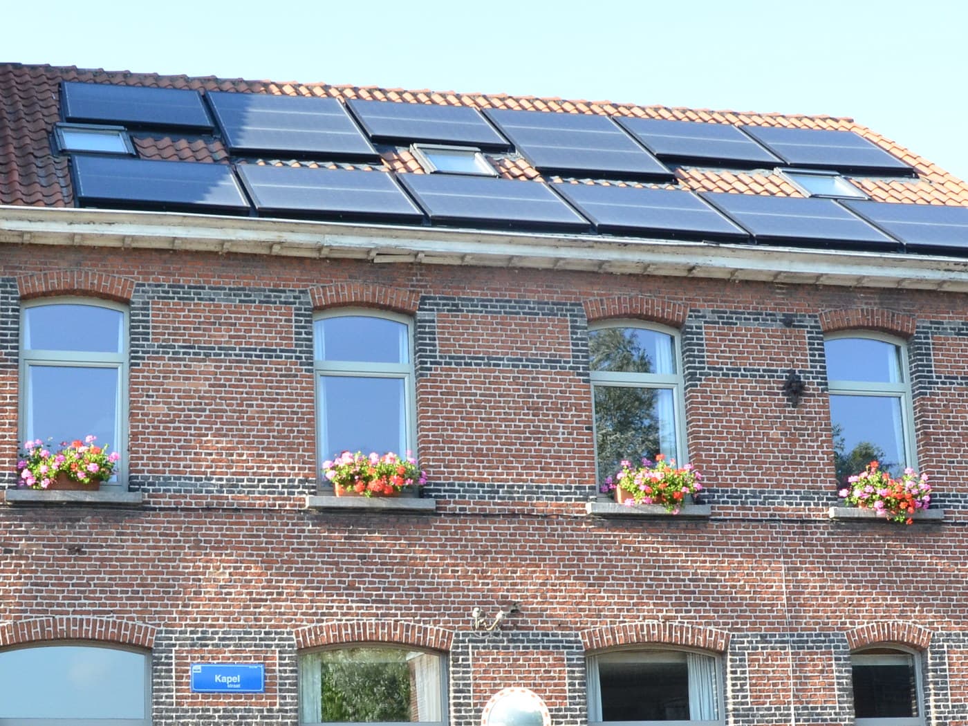 Zonnepanelen op het pannendak van een Vlaamse rijwoning
